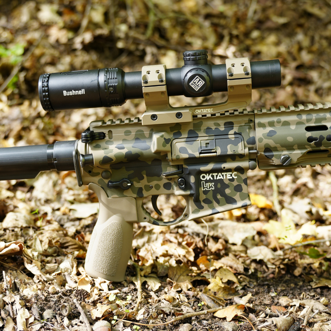 Langwaffe mit Cerakote-Tarnmuster liegt getarnt im herbstlichen Laub.