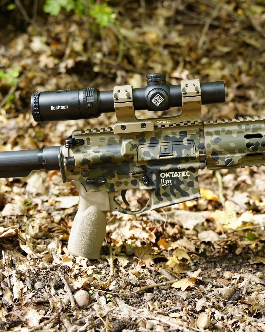 Langwaffe mit Cerakote-Tarnmuster liegt getarnt im herbstlichen Laub.